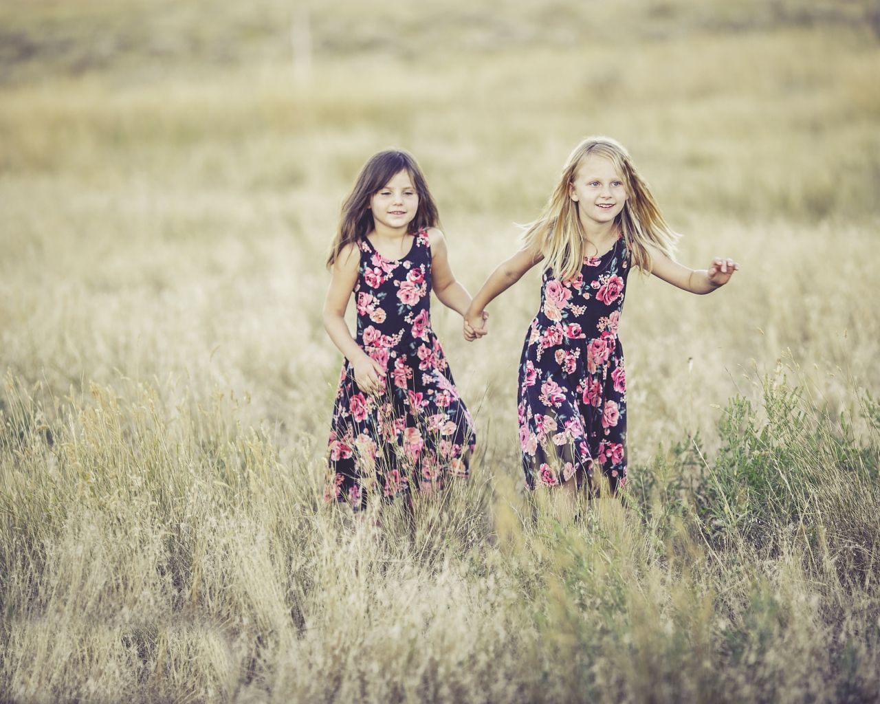 Две маленькие девочки бегут по траве