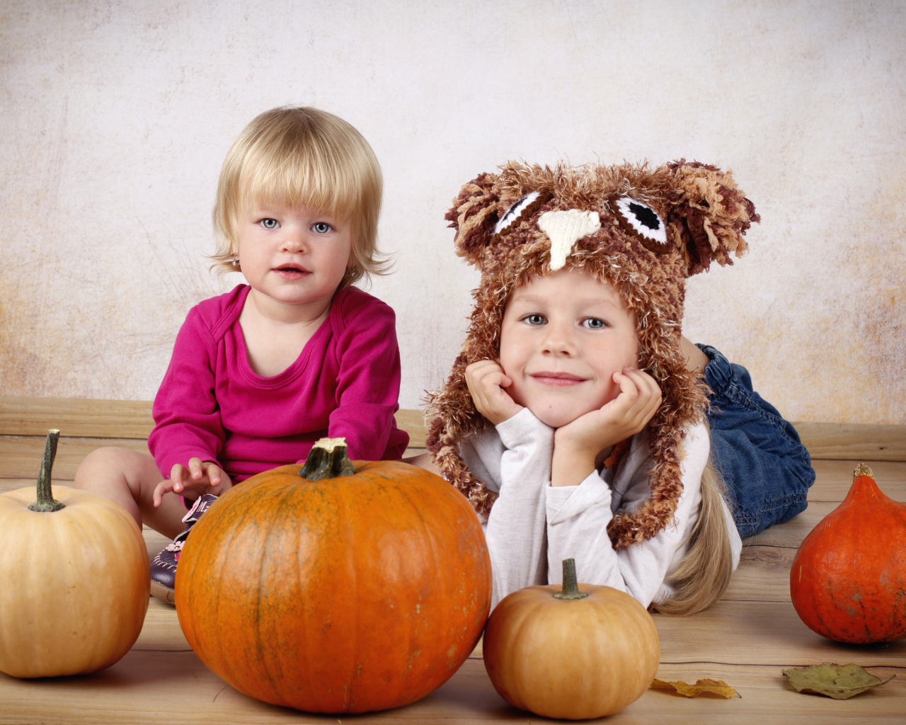 Два маленьких ребенка с тыквами в комнате