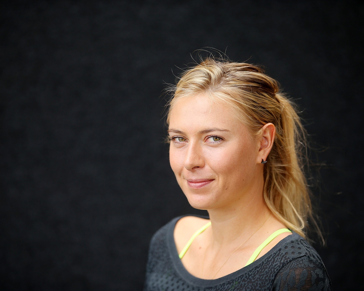 Улыбающаяся блондинка, теннисистка Мария Шарапова на сером фоне