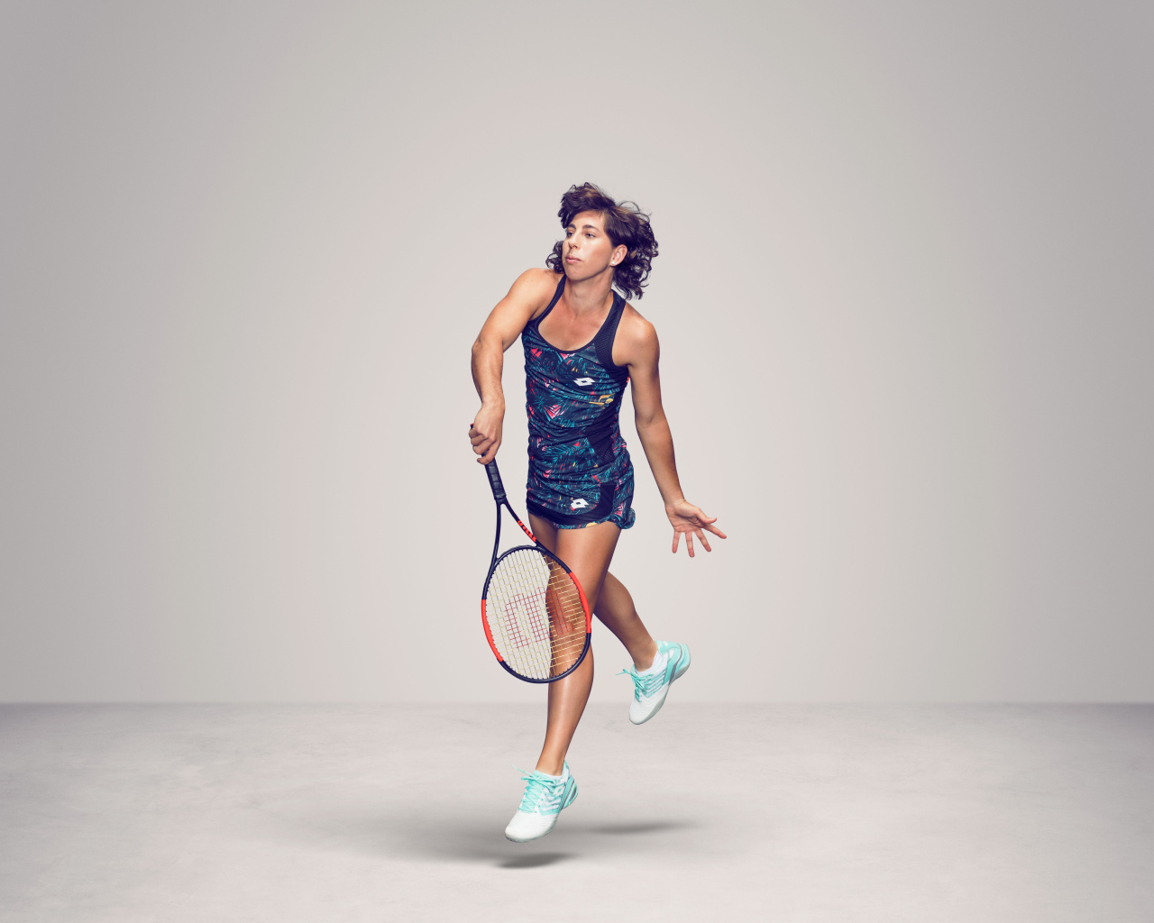 Испанская теннисистка Карла Суарес Наварро с ракеткой на сером фоне