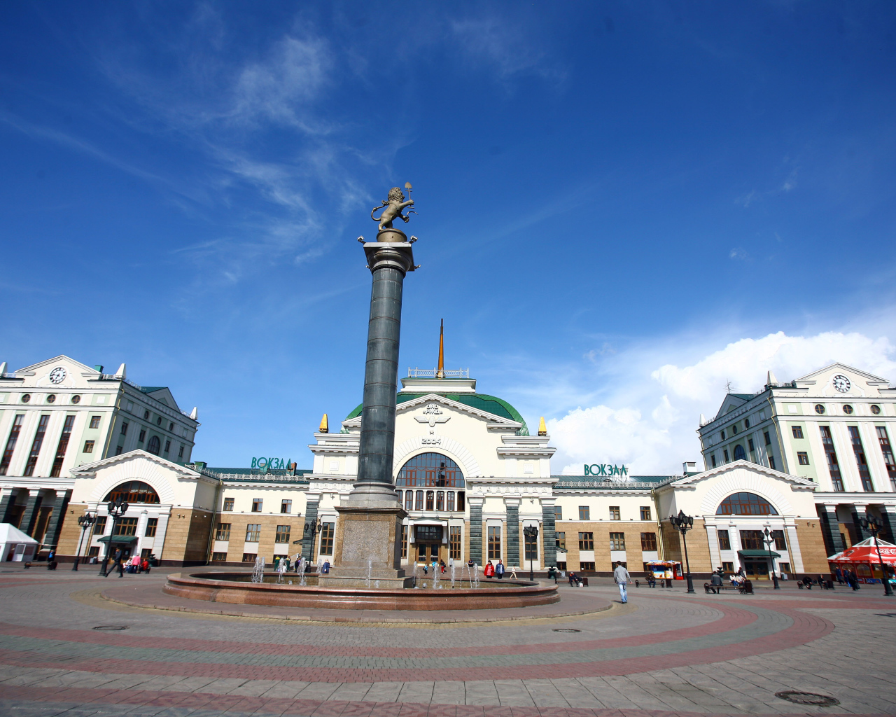 Памятник у здания железнодорожного вокзала под красивым голубым небом, Красноярск. Россия