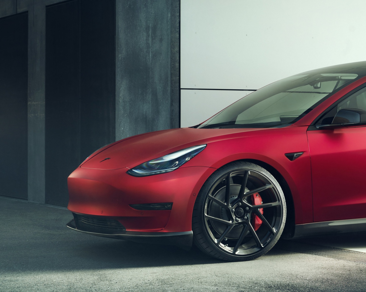 Красный автомобиль Tesla Model 3 2019 года выезжает в гаража