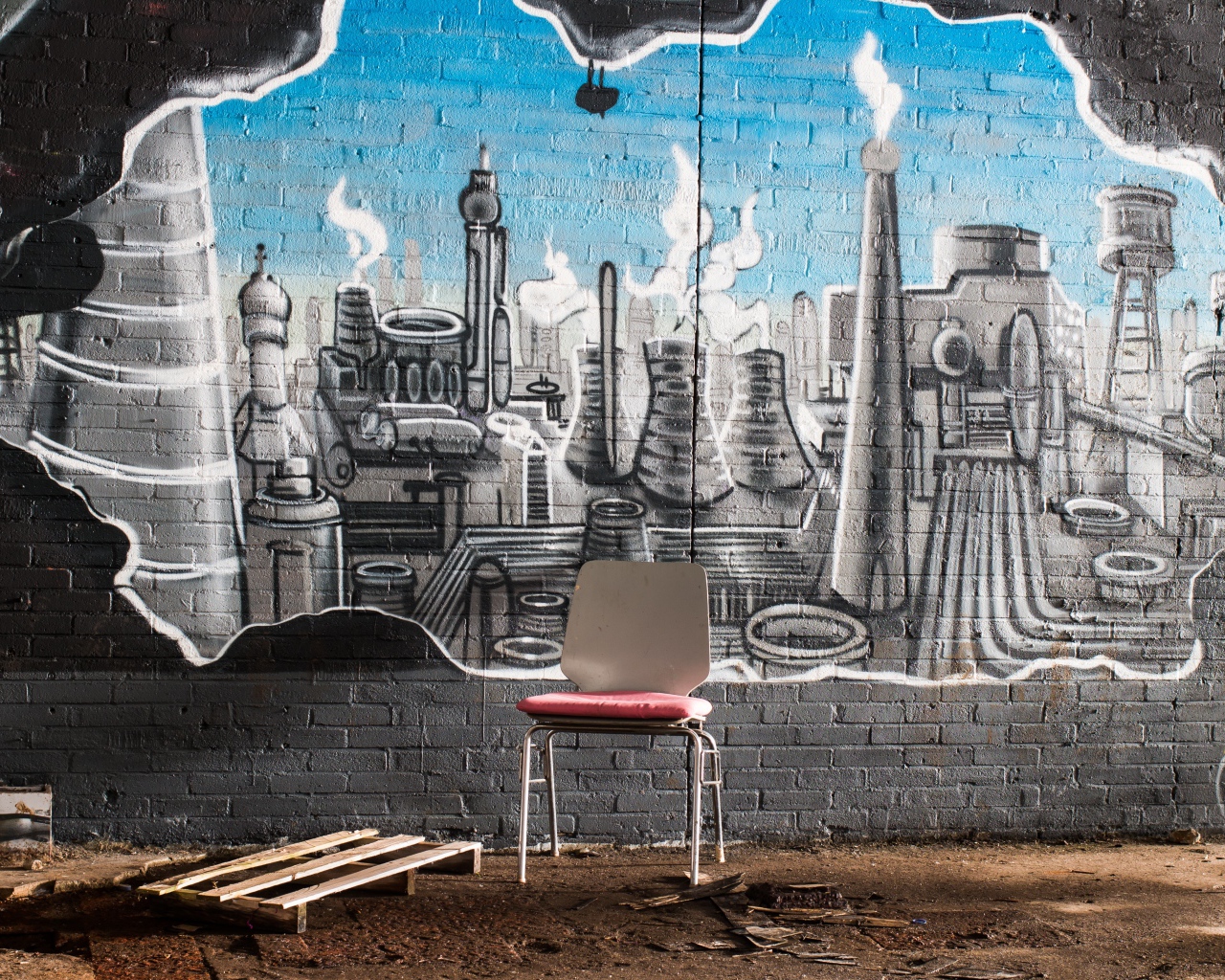 A chair stands by a brick wall with graffiti