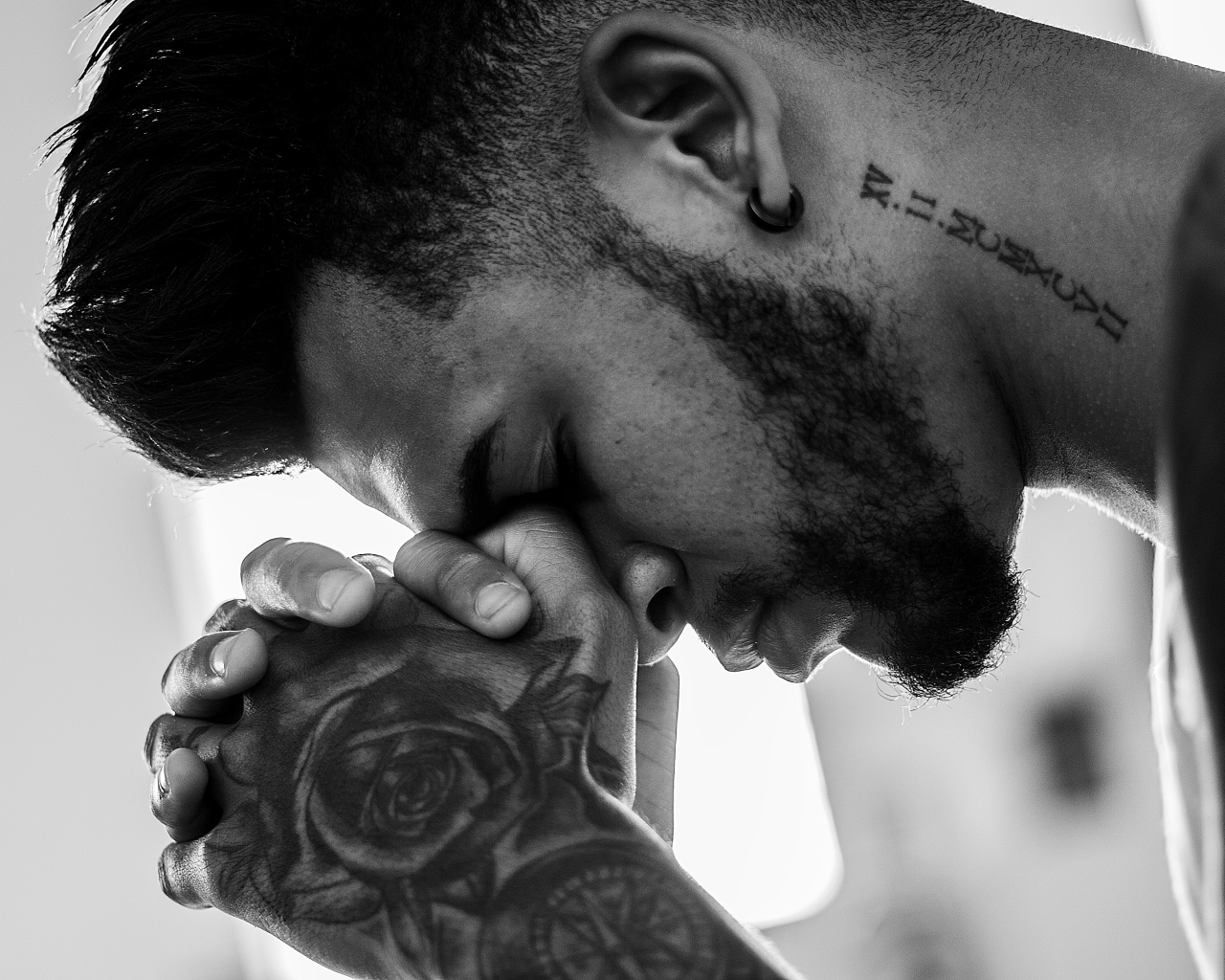 A man with tattoos on his arm and neck