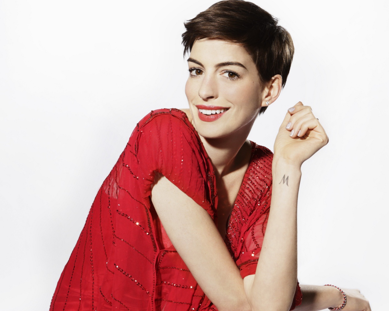 Актриса Энн Хэтэуэй в красном наряде с короткой стрижкой