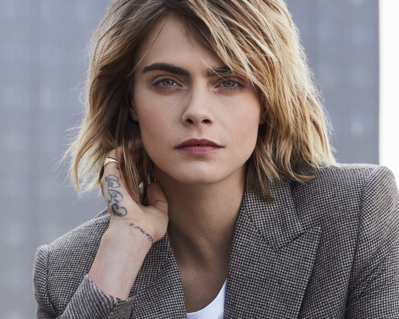 Актриса Кара Делевинь в пиджаке с татуировкой на руке