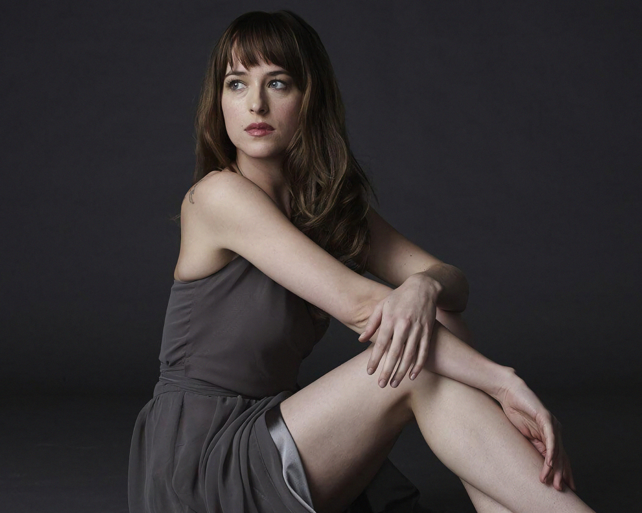 Актриса Дакота Джонсон в платье на сером фоне