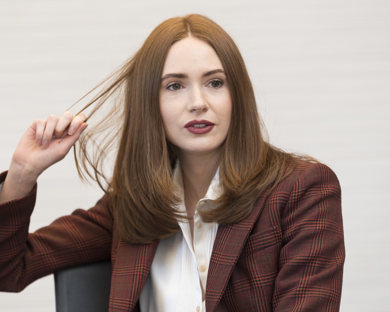 Актриса Карен Гиллан в пиджаке держит волосы