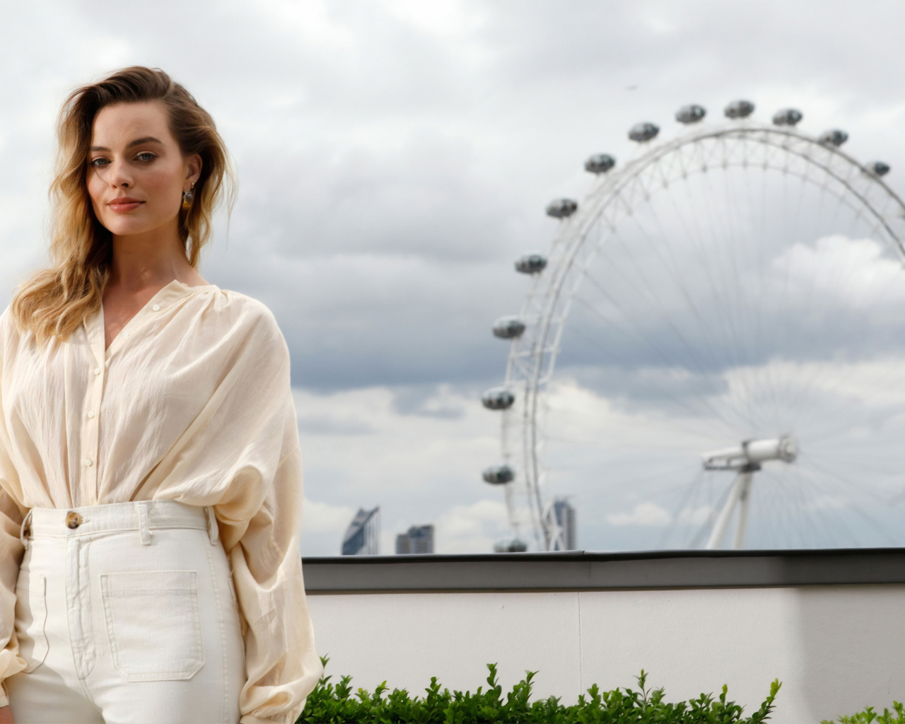 Актриса Марго Робби на  фоне аттракциона  колесо обозрения