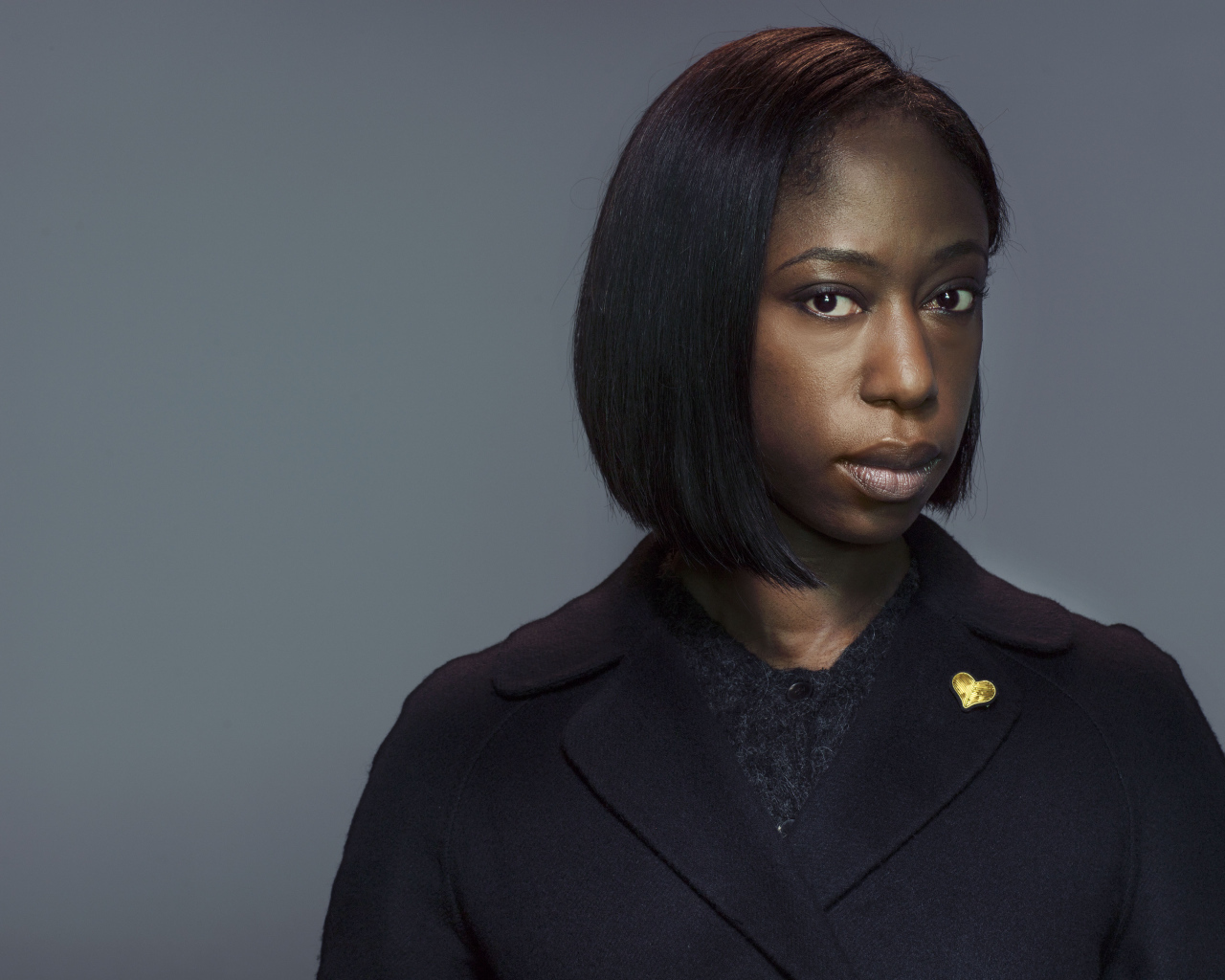 Актриса Никки Амука-Бёрд на сером фоне