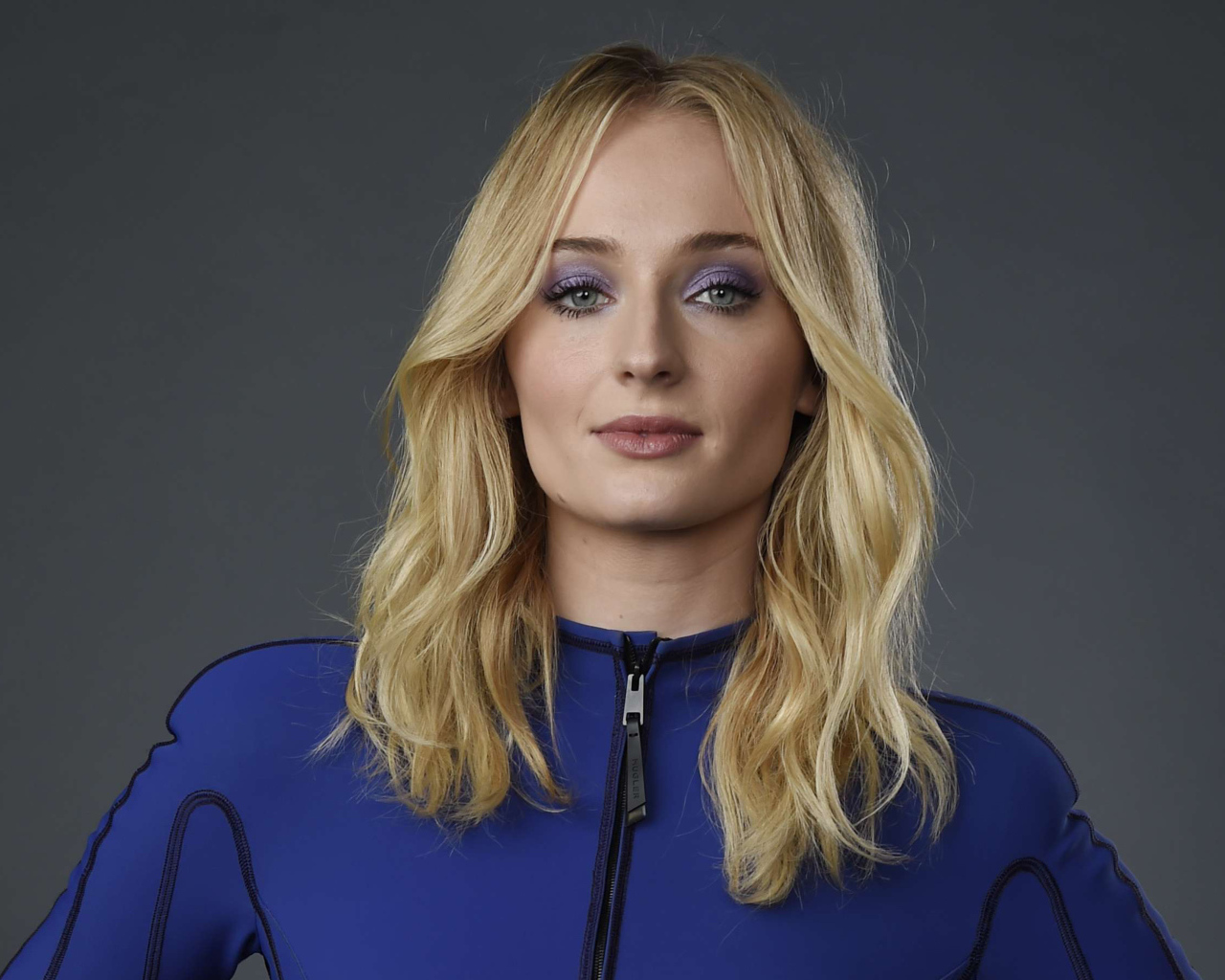 Актриса Софи Тернер крупным планом на сером фоне