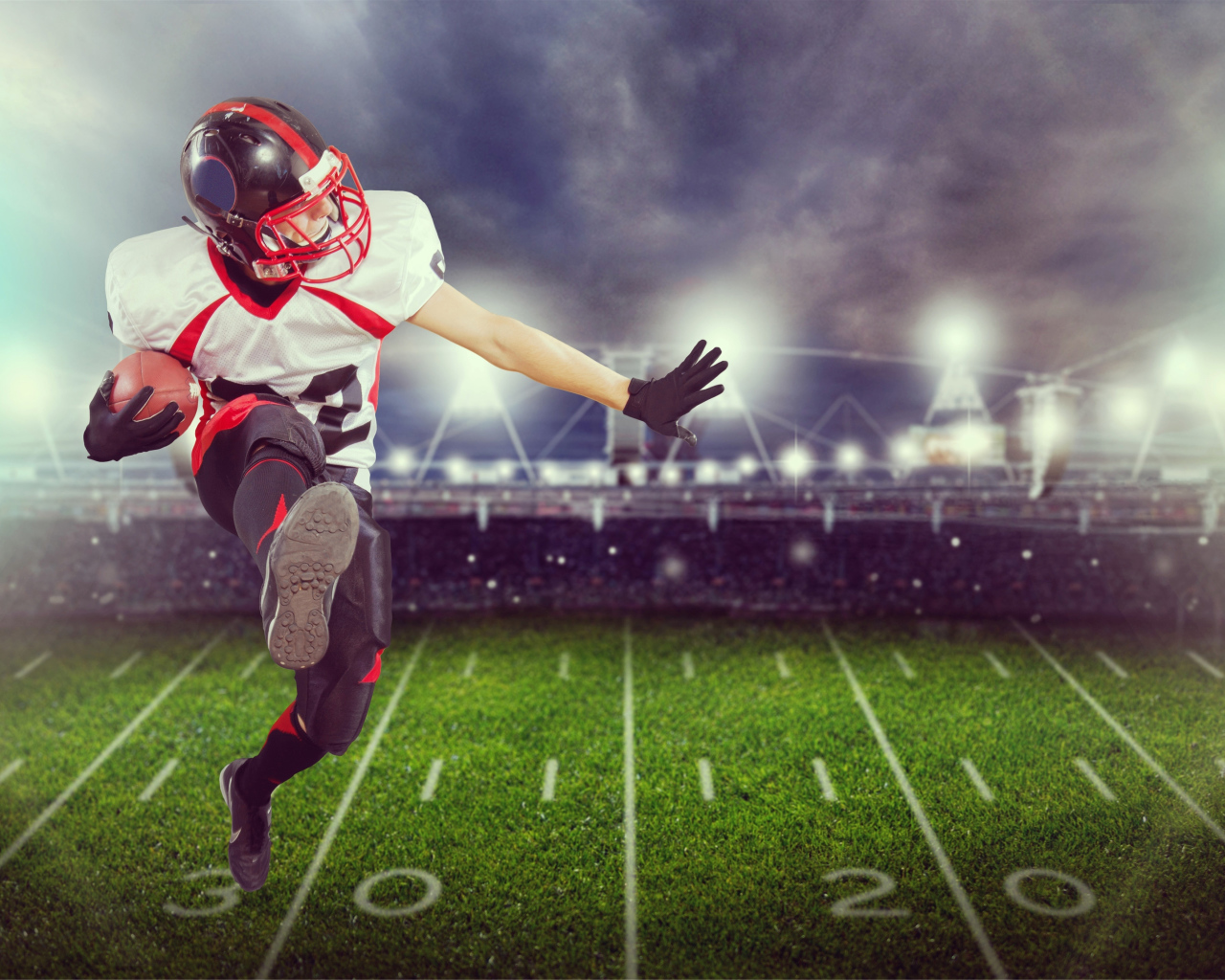 Игрок в американский футбол с мячом на поле