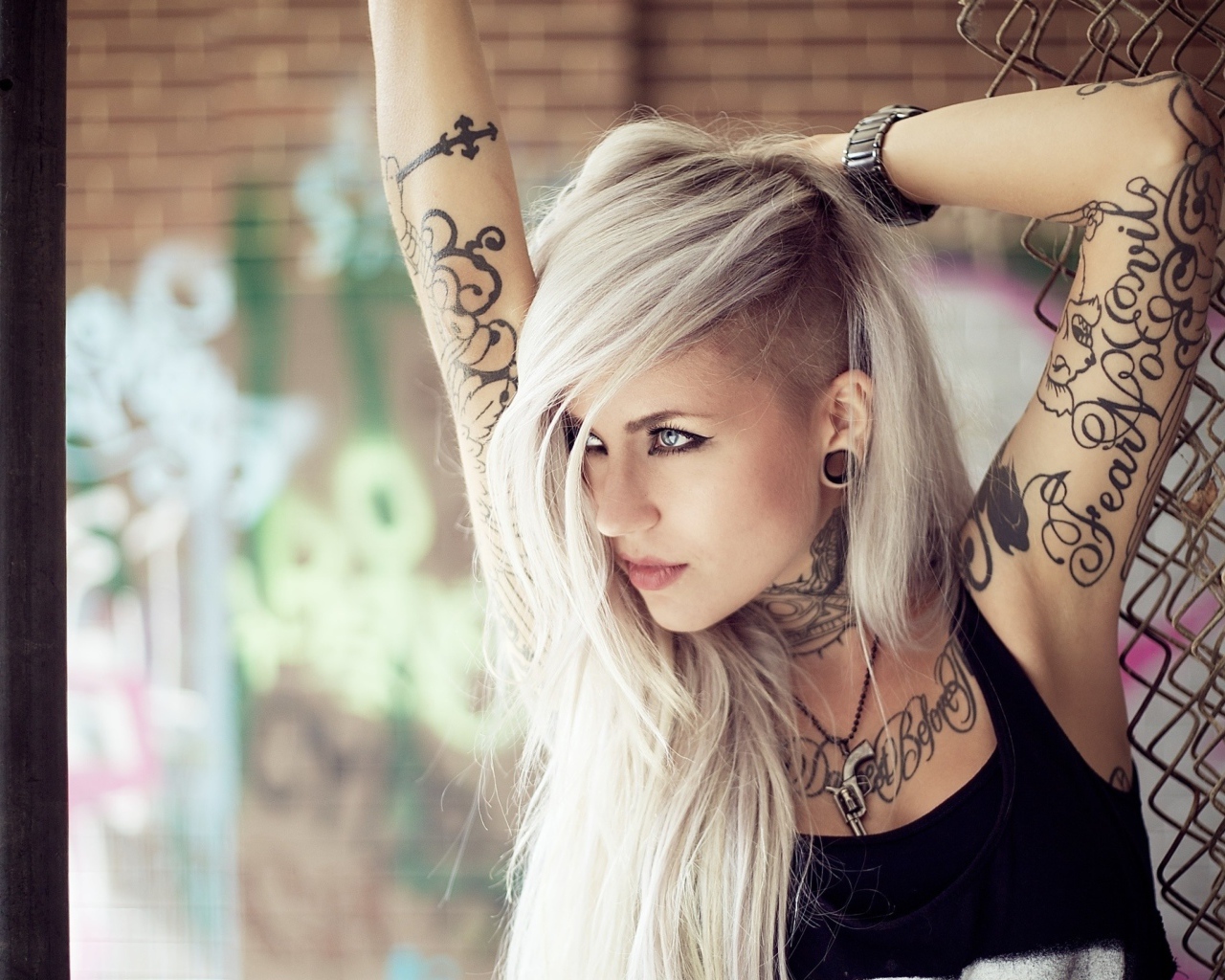 Красивая блондинка с татуировками на теле