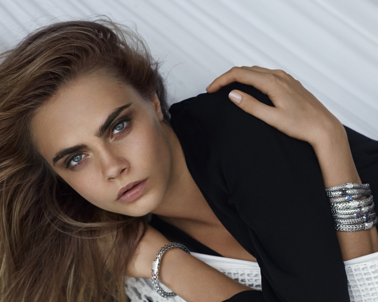 Красивая девушка актриса, модель Кара Делевинь с браслетами на руках