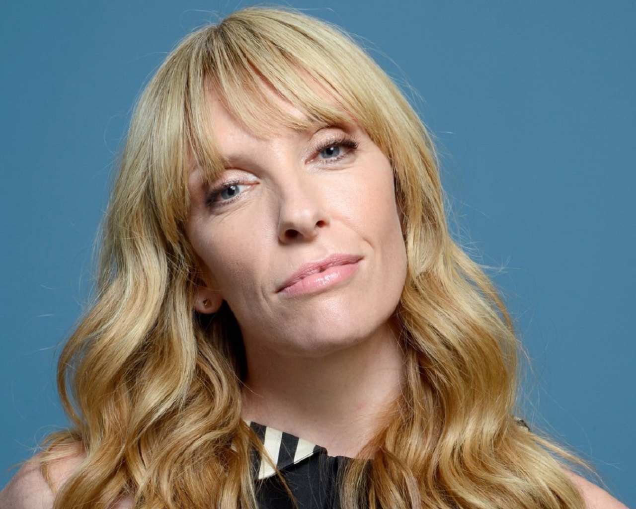 Голубоглазая блондинка, актриса Тони Коллетт на голубом фоне