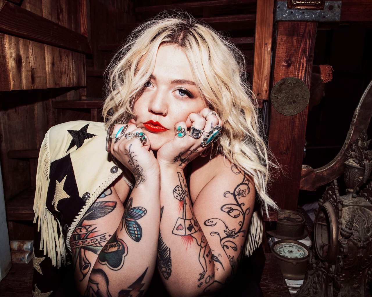 Голубоглазая блондинка с татуировками на руках