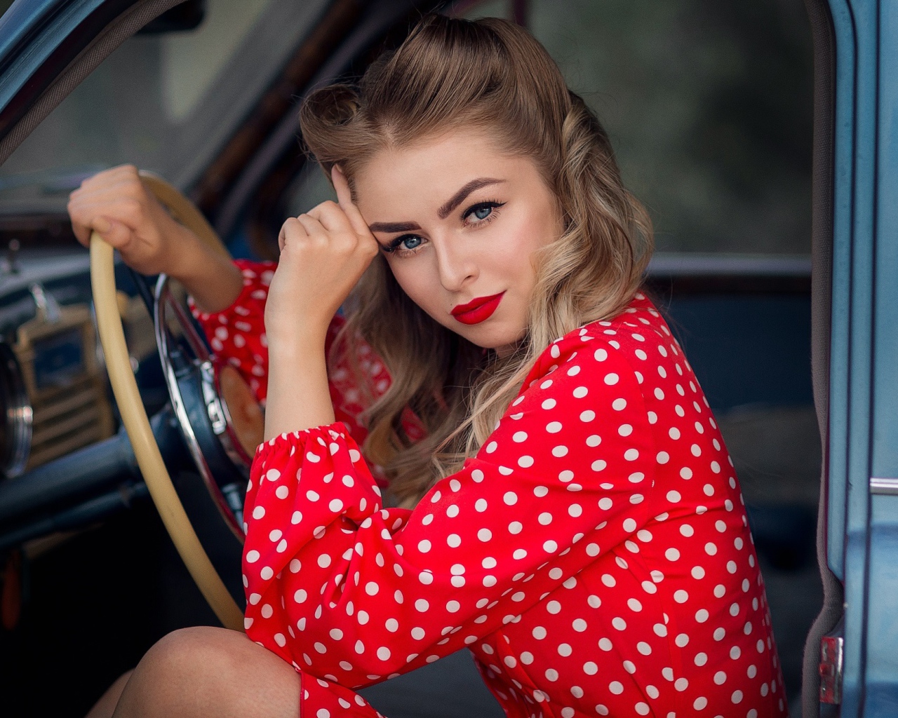 Blue-eyed retro girl driving a car