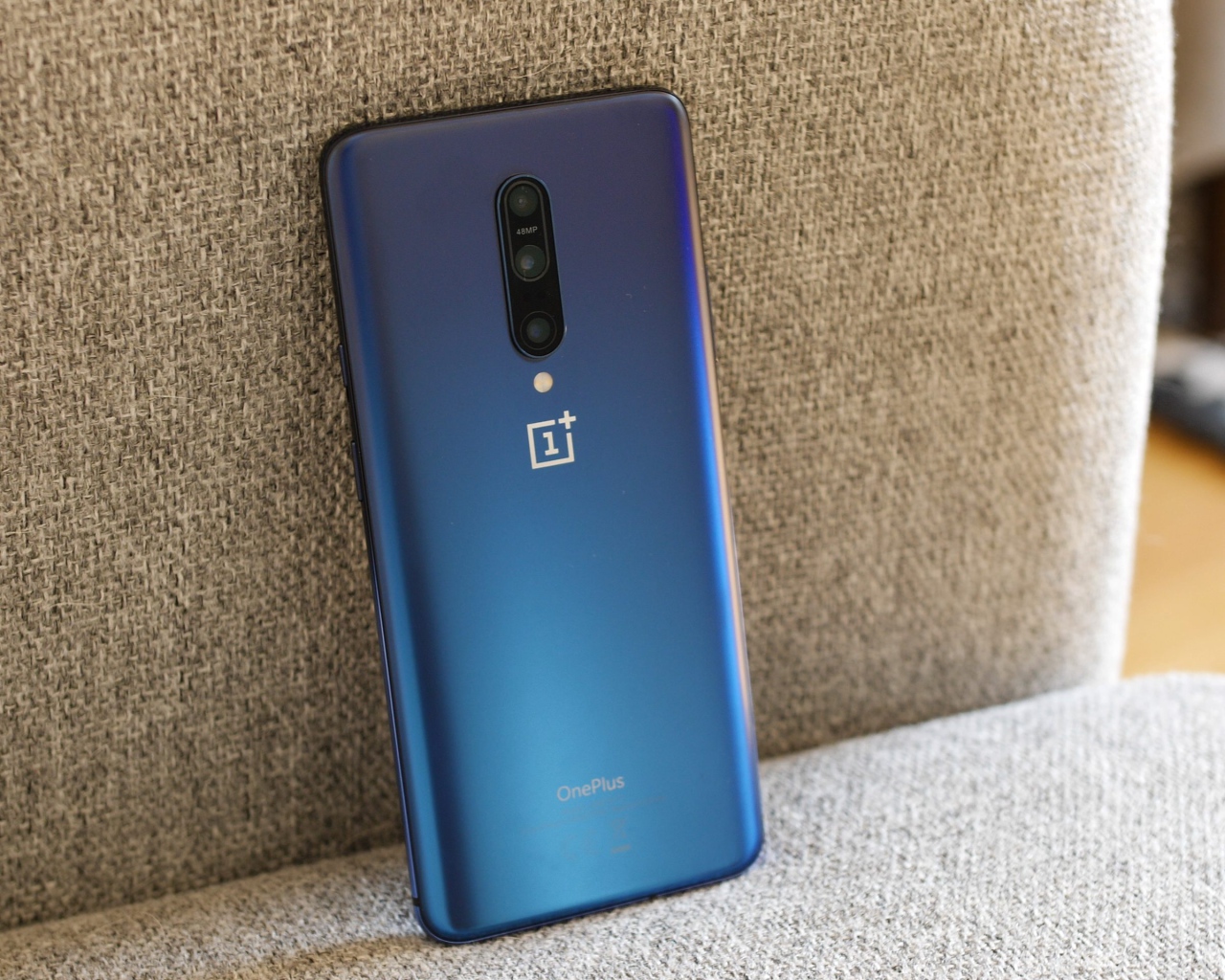 Синий смартфон ONEPLUS 7 на диване