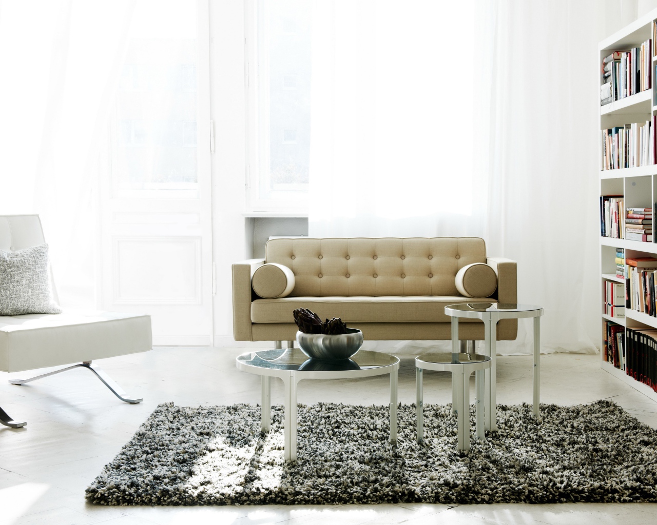 Светлая гостиная с книжным шкафом, диваном и креслом