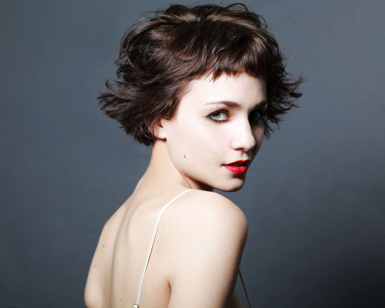 Яркая девушка с короткой стрижкой, актриса Таппенс Мидлтон на сером фоне