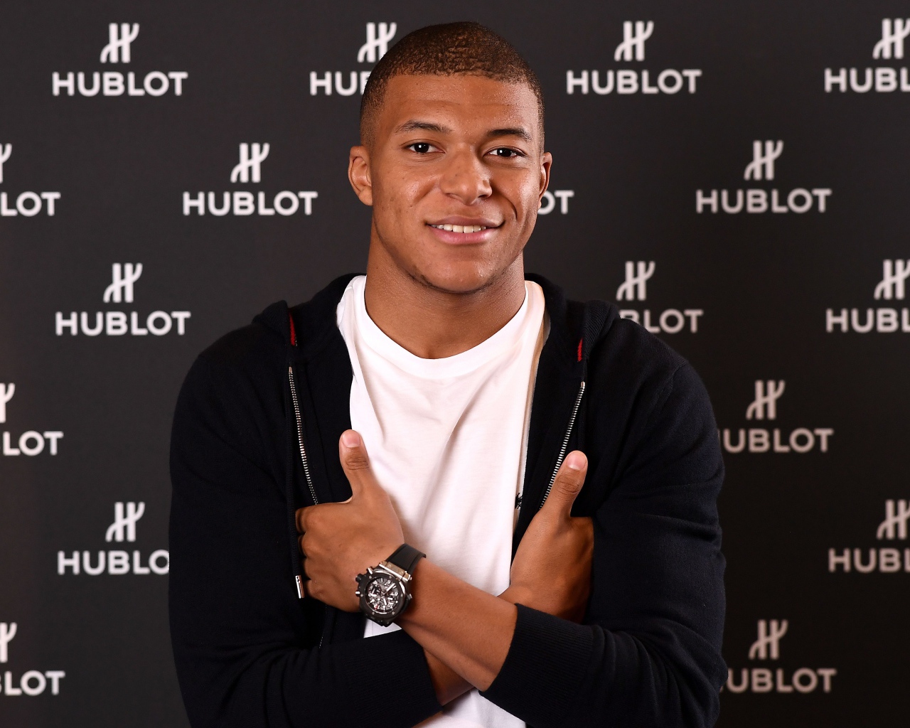 Футболист Килиан Мбаппе в костюме с часами на руке