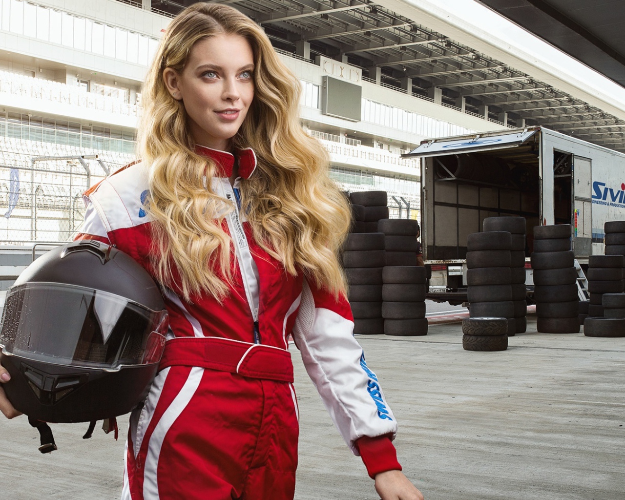 Девушка гонщица с шлемом в руках