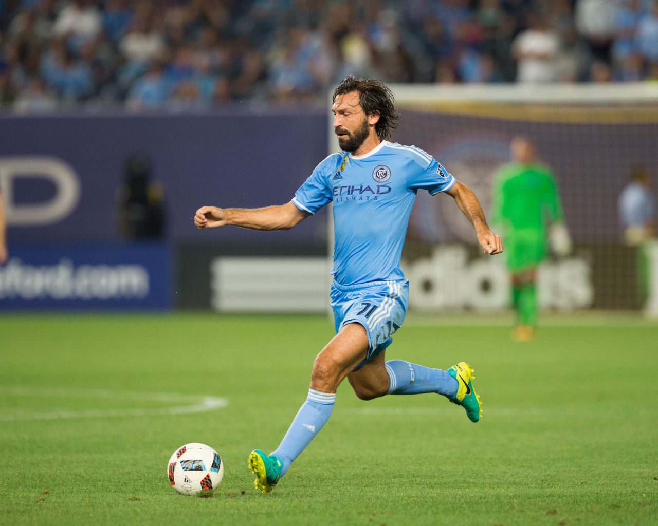 Итальянский футболист Андреа Пирло отбивает мяч на футбольном поле