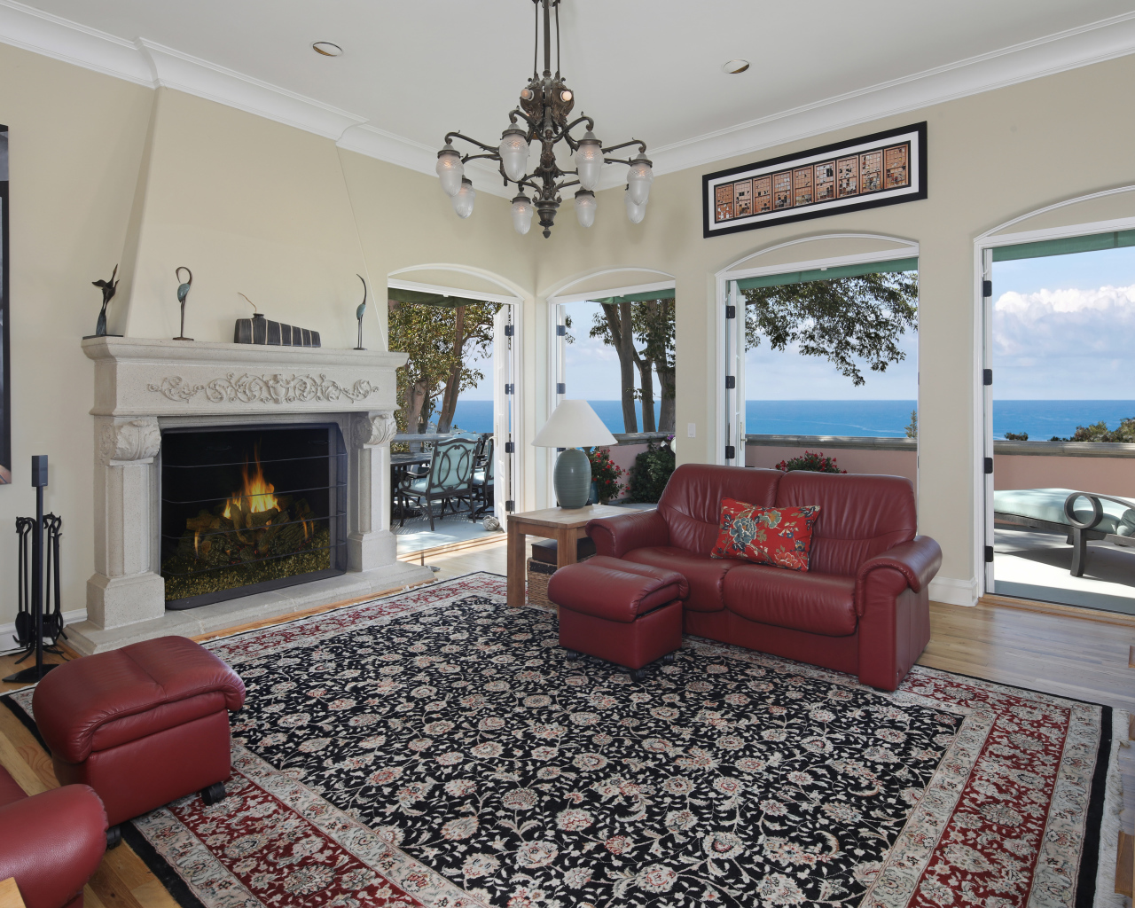 Гостиная с кожаным диваном, большими окнами и камином 