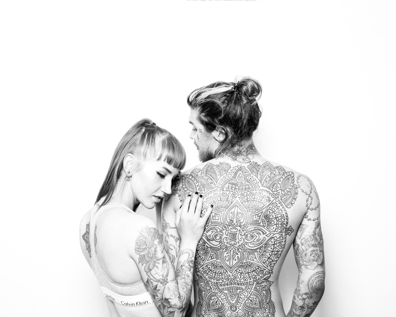 Мужчина и девушка с татуировками на теле на белом фоне