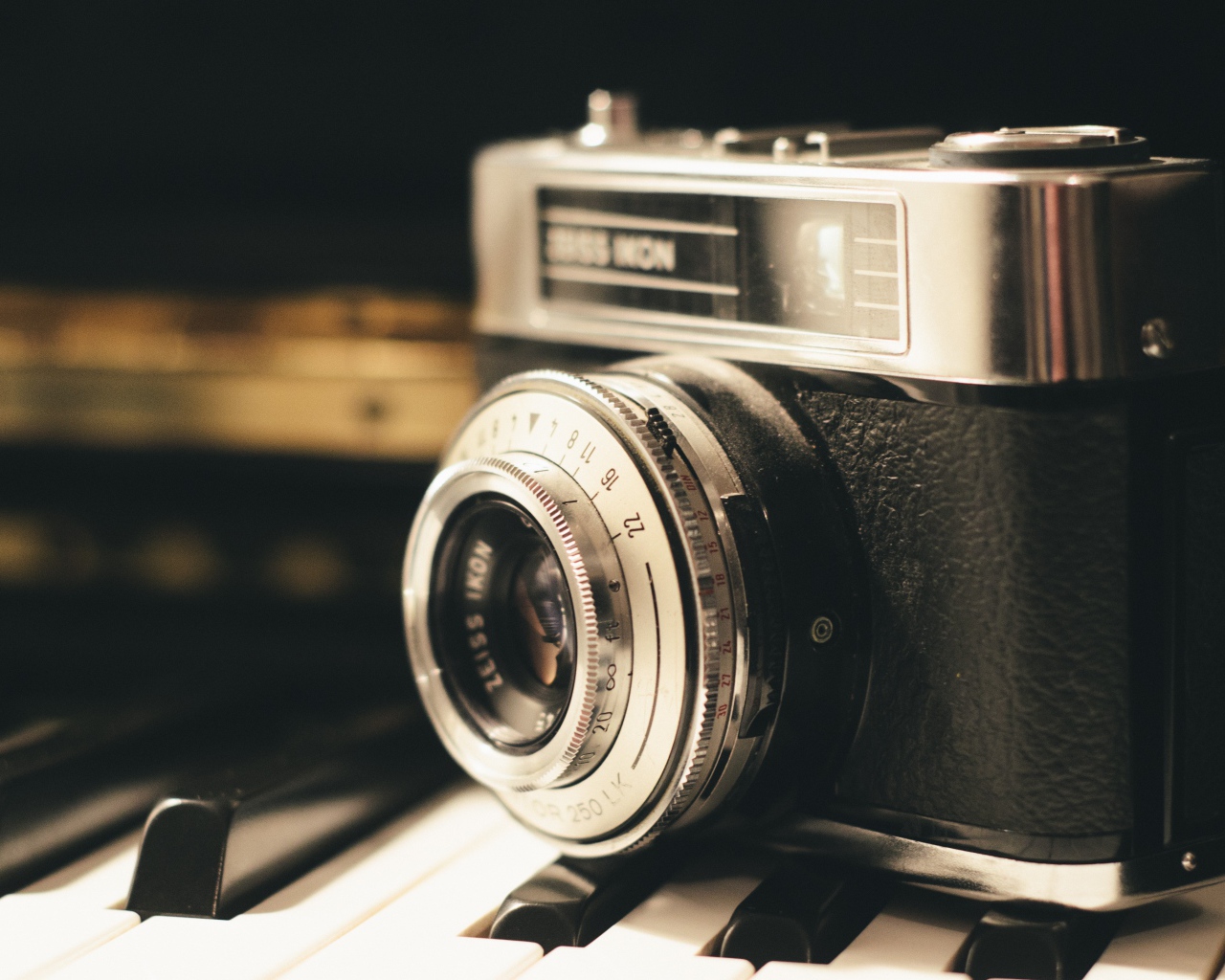 Старый фотоаппарат Zeiss Ikon стоит на клавишах пианино