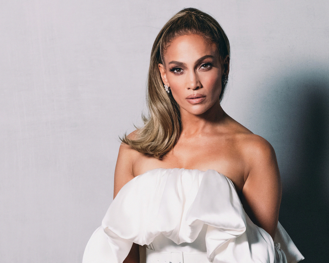 Популярная актриса и певица Дженнифер Лопес на сером фоне