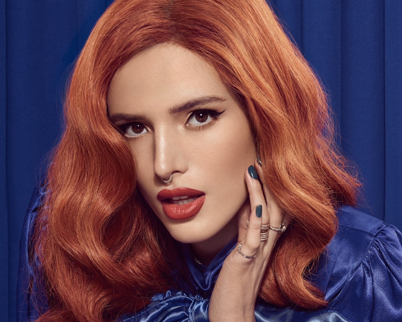 Рыжеволосая актриса Белла Торн на синем фоне