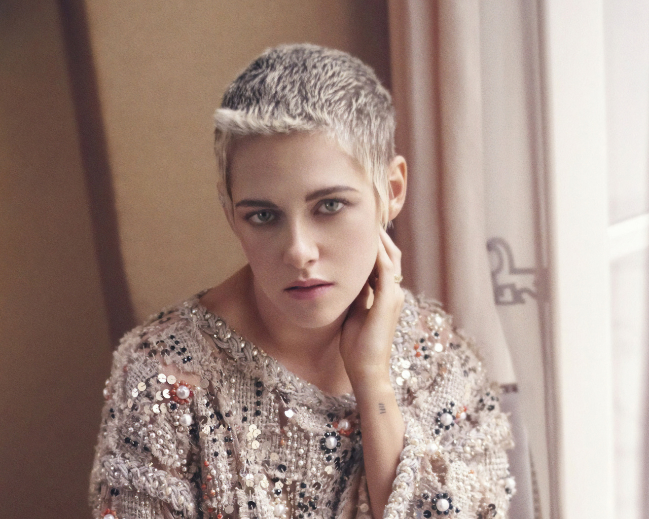 Актриса Кристен Стюарт с короткой стрижкой у окна