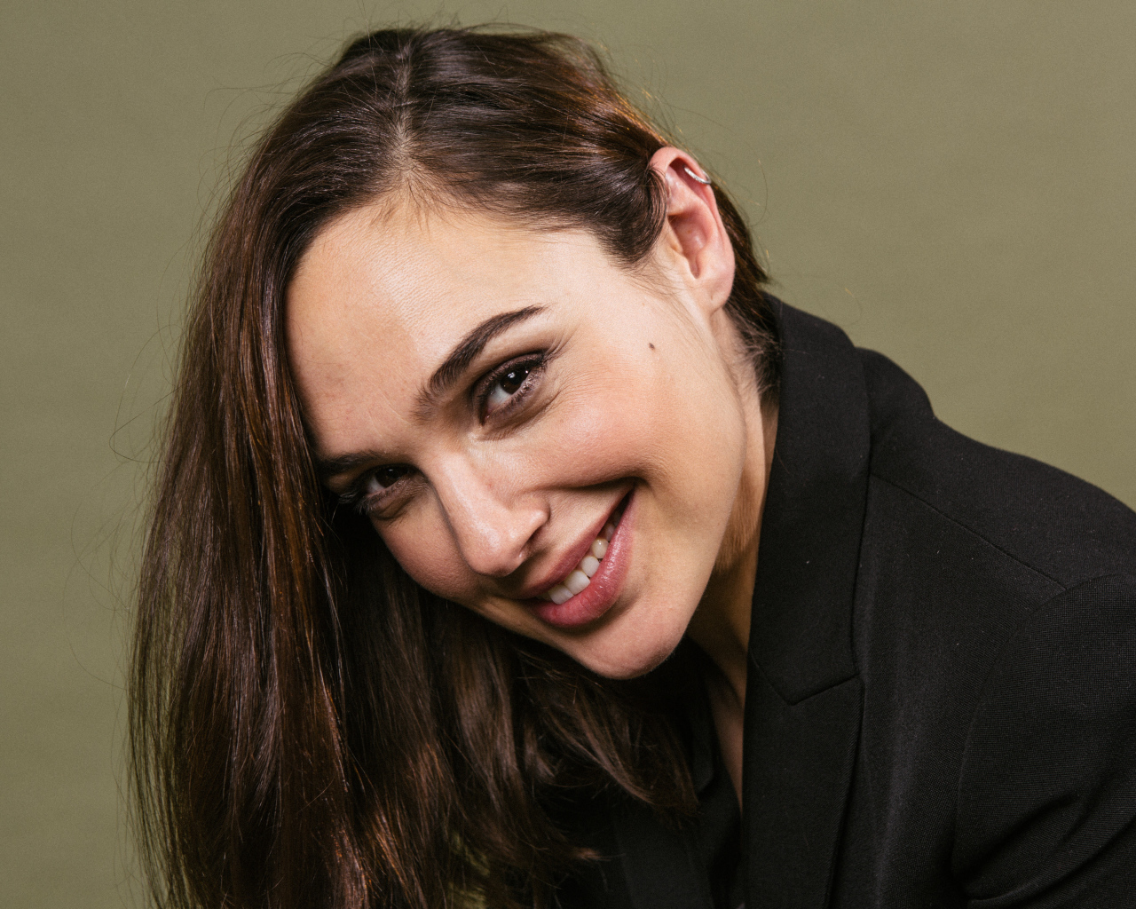 Улыбающаяся актриса Галь Гадот  в черном пиджаке