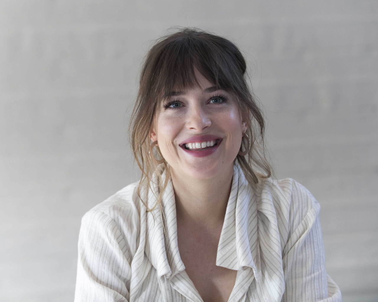 Улыбающаяся девушка актриса Дакота Джонсон в рубашке