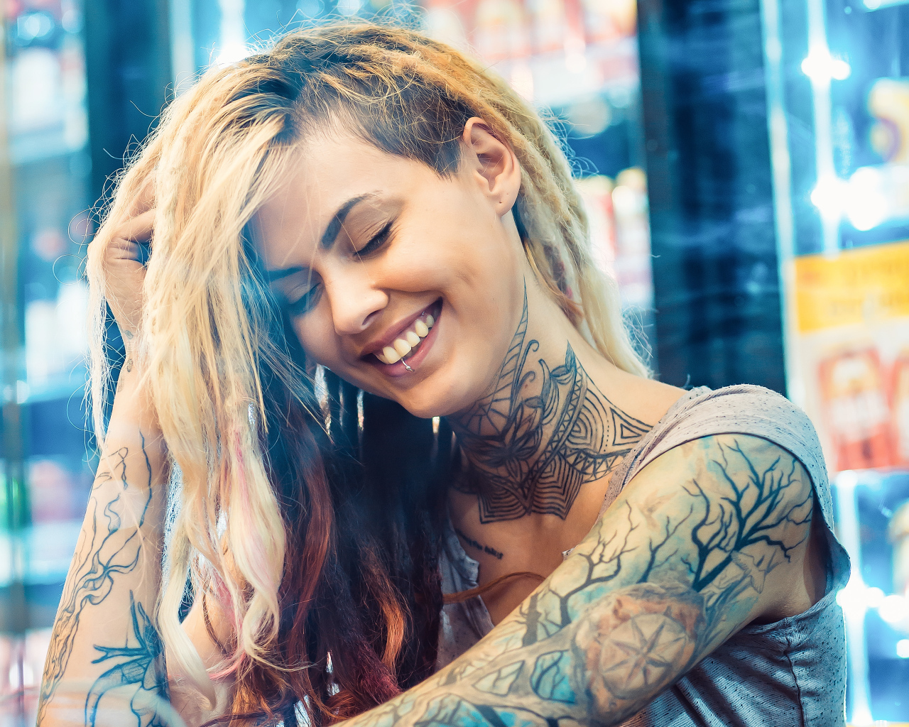 Улыбающаяся девушка с татуировками на теле