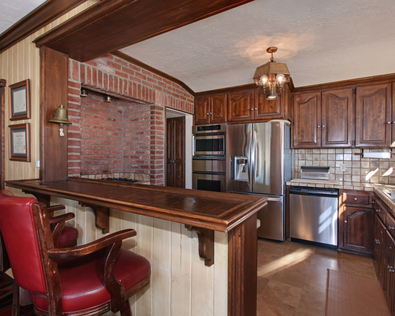 Spacious kitchen with wooden furniture and leather chairs