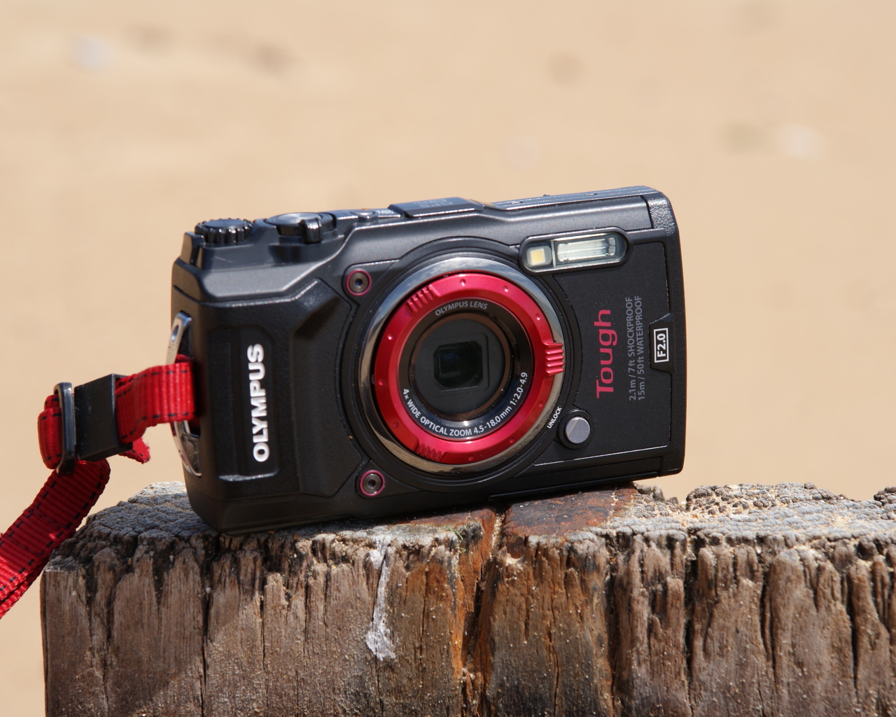 Стильный фотоаппарат Olympus Tough TG-5 стоит на пне