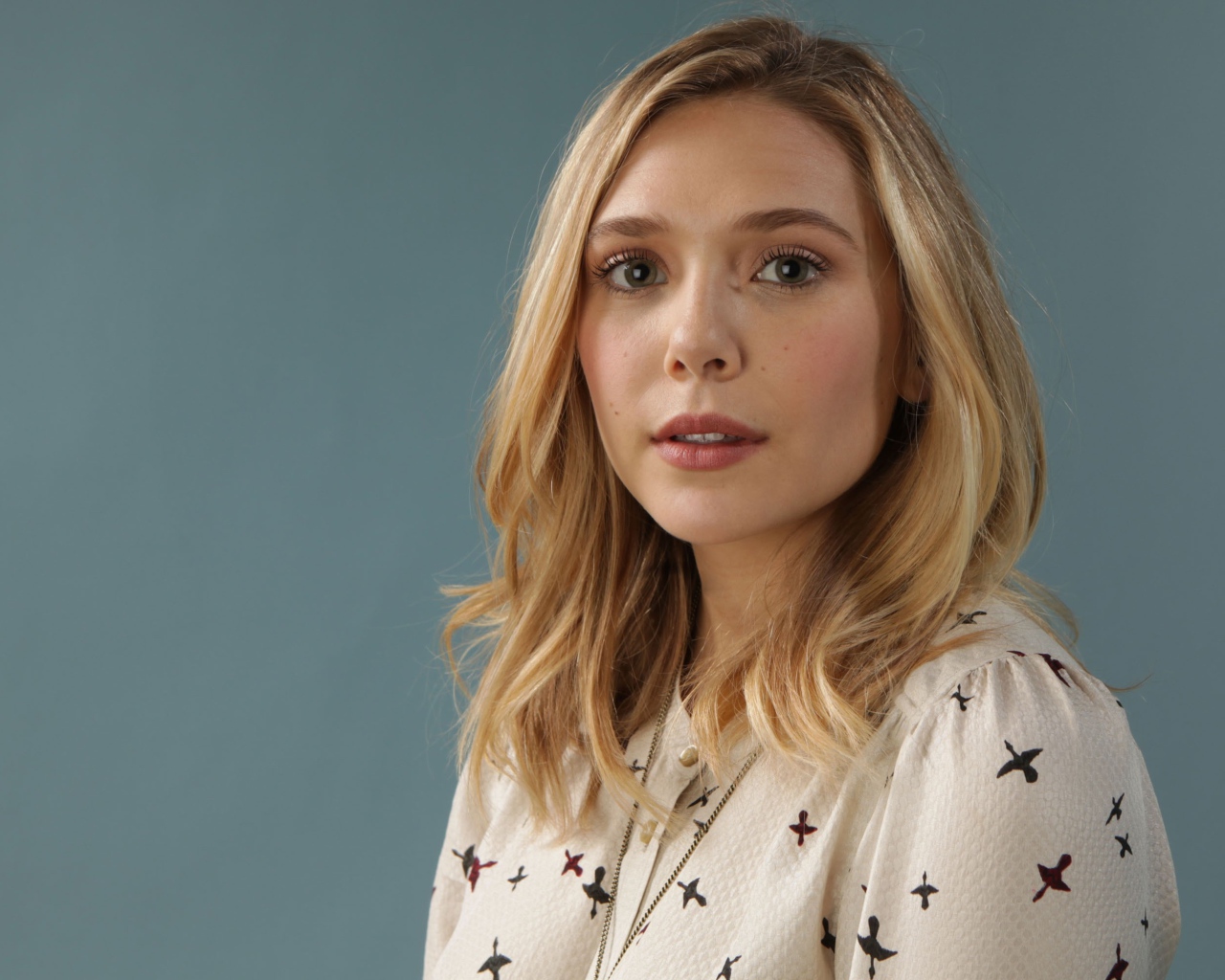 Нежная девушка, актриса Элизабет Олсен на сером фоне