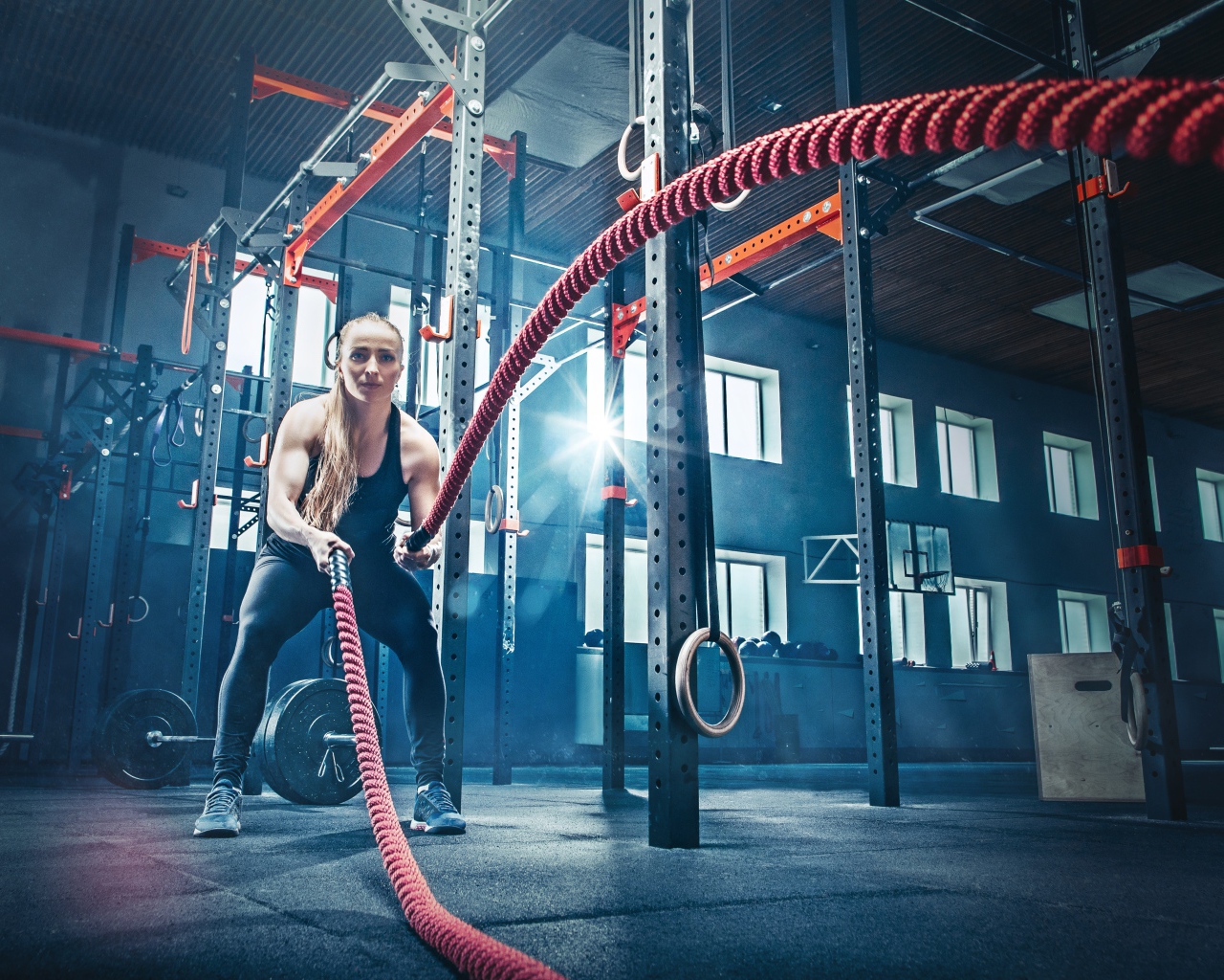 Девушка в спортзале занимается с канатами