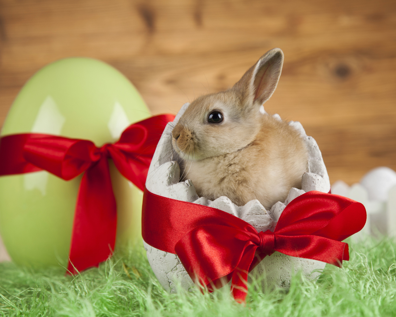 Little decorative rabbit in an egg with a red bow