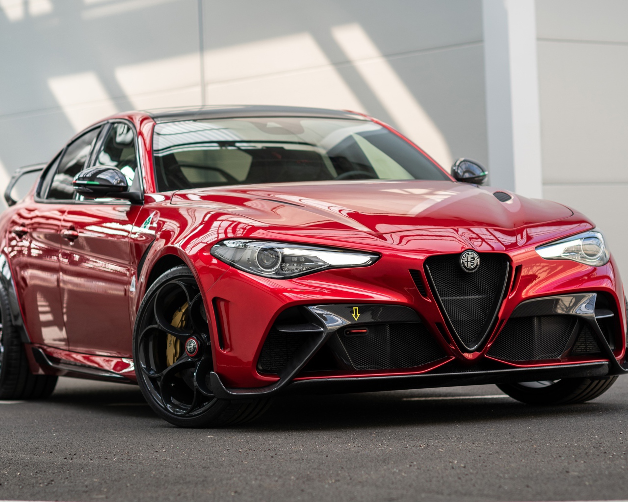 Красный автомобиль Alfa Romeo Giulia GTAm 2020 года у гаража