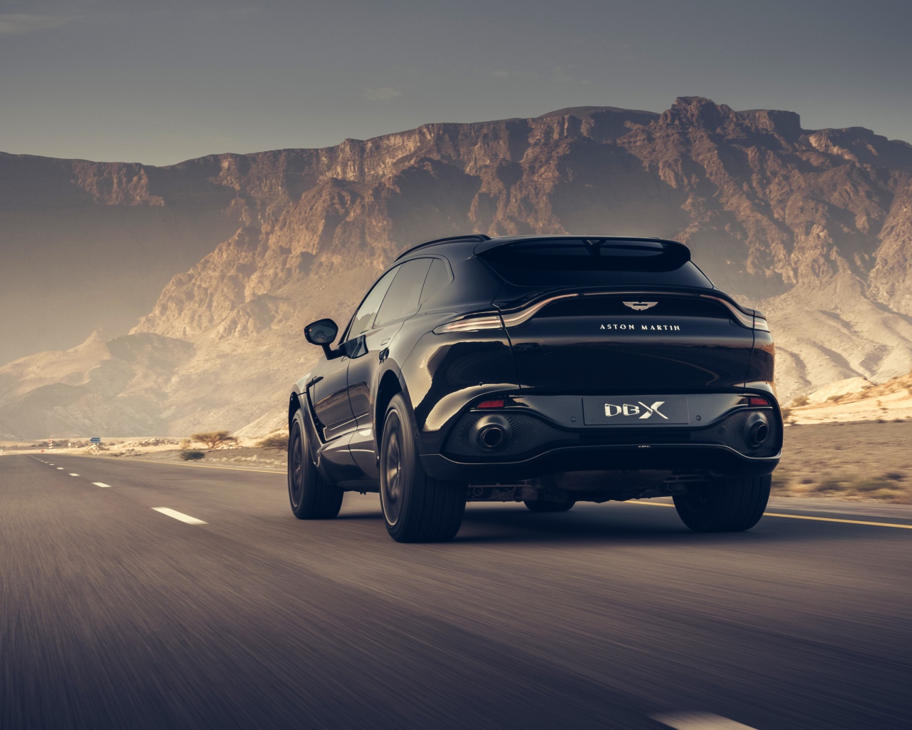 Черный внедорожник Aston Martin DBX 2020 года в горах 