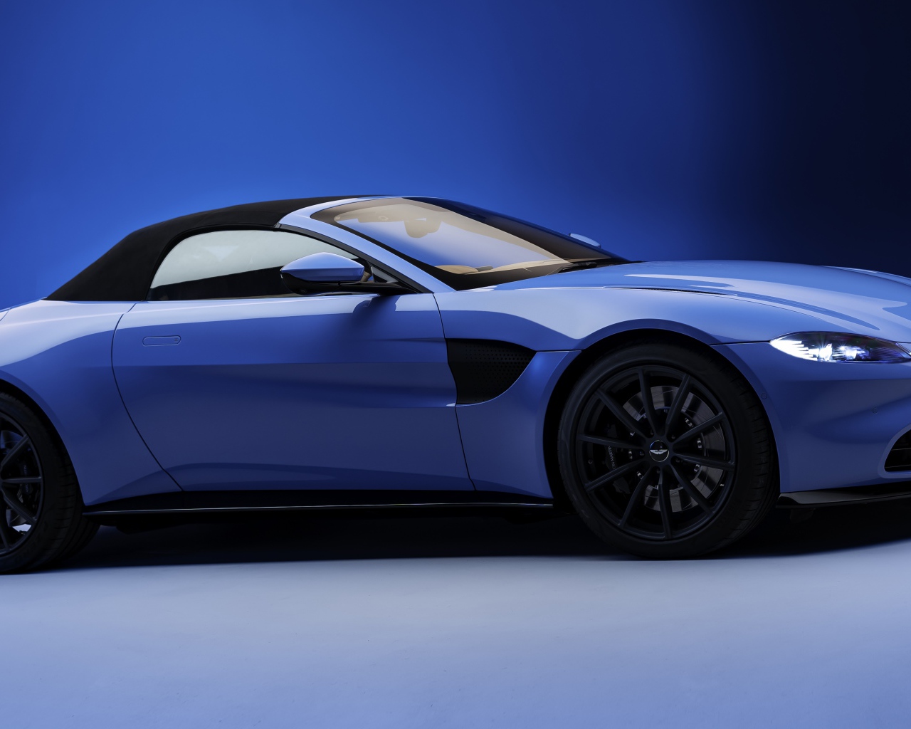 Синий автомобиль Aston Martin Vantage Roadster 2020 года 