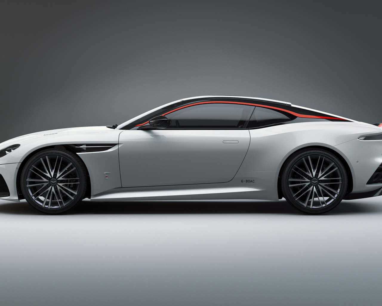 Серебристый автомобиль Aston Martin DBS Superleggera 2019 года вид сбоку