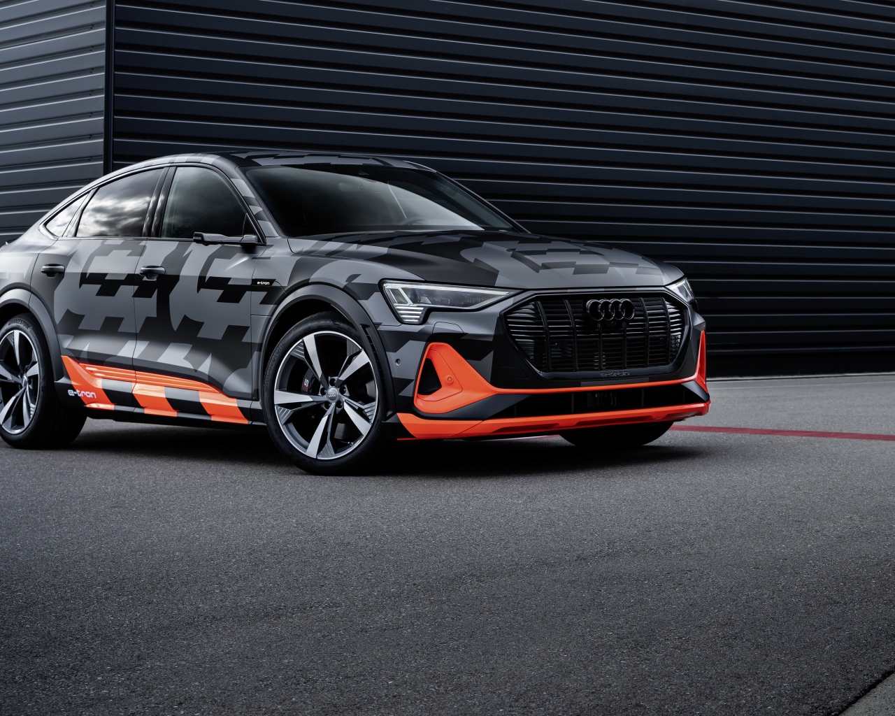 Автомобиль Audi E-Tron S Sportback Prototype 2020 года на фоне черной стены 