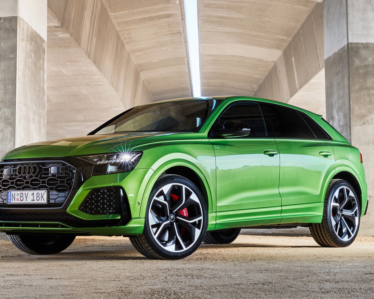 Зеленый автомобиль Audi RS Q8 2020 года под мостом