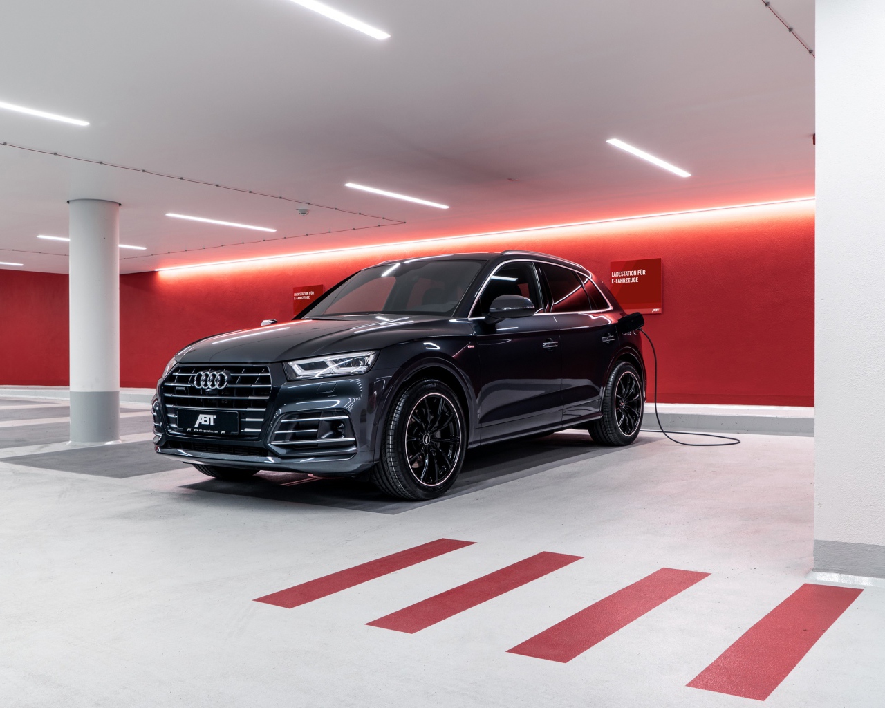 Черный автомобиль ABT Audi Q5 55 TFSI E 2020 года на заправке 