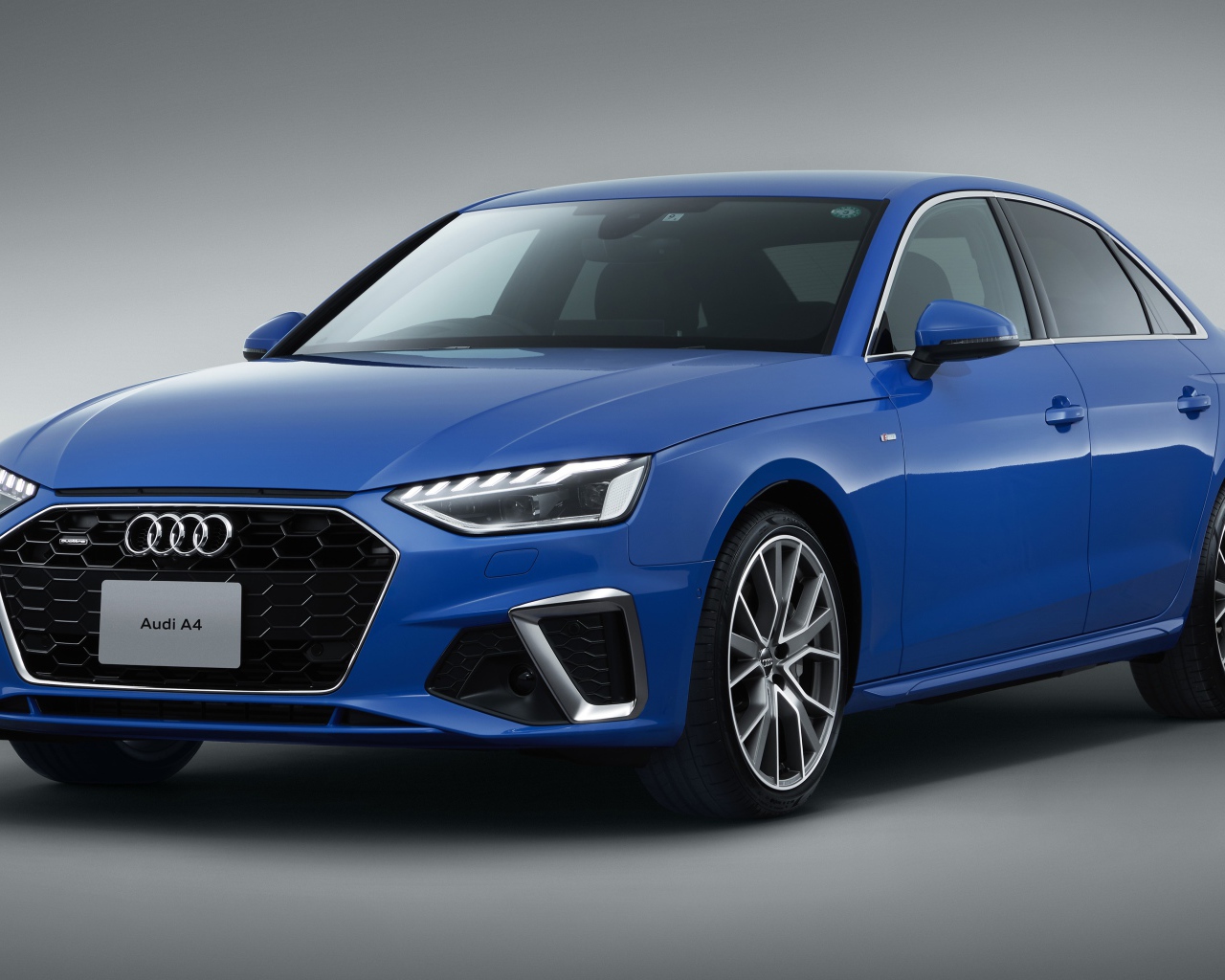 Синий автомобиль Audi A4 45 TFSI Quattro S Line 2020 года на сером фоне 