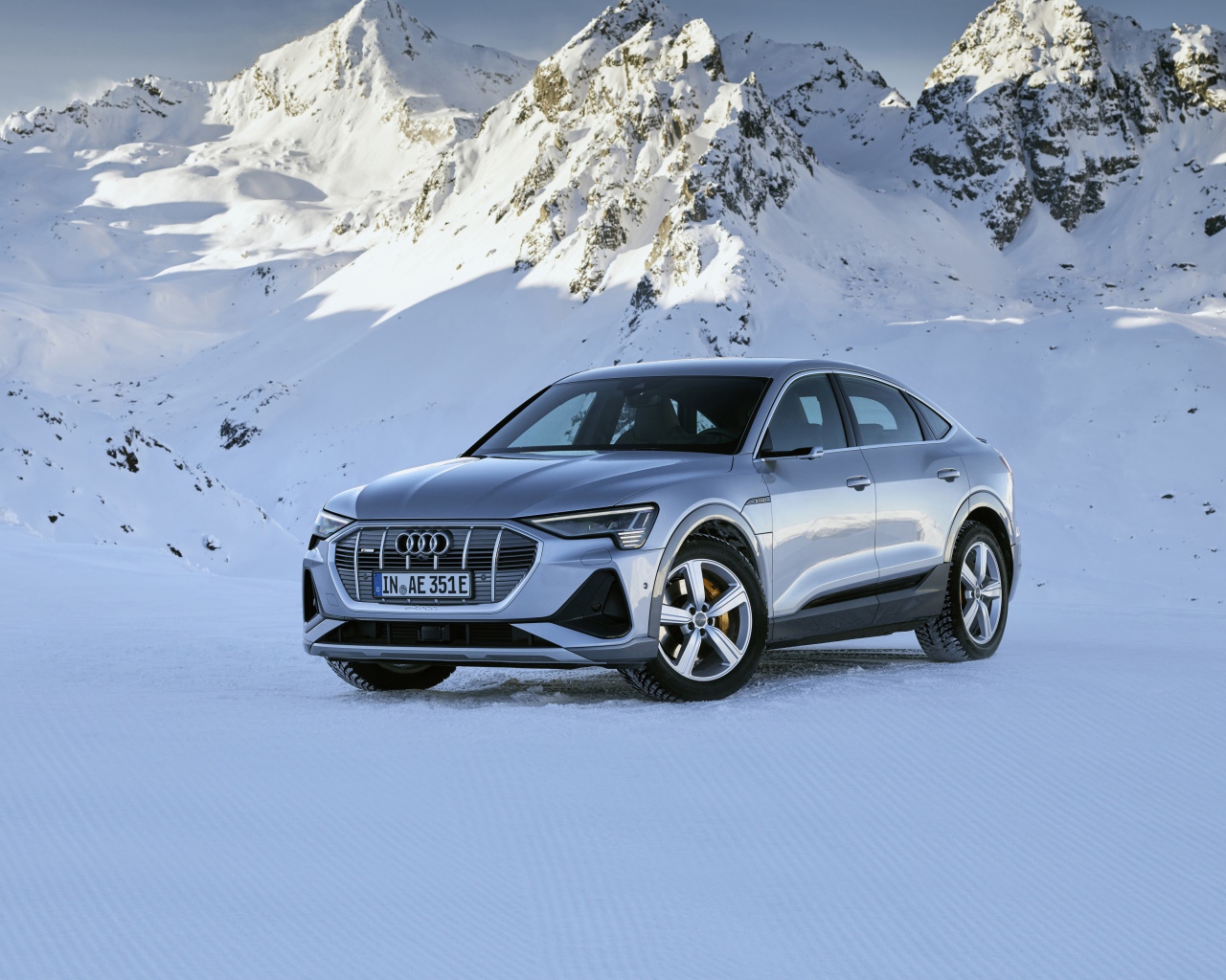Автомобиль Audi E-Tron 55 Quattro Sportback S Line, 2020 года на фоне заснеженных гор 